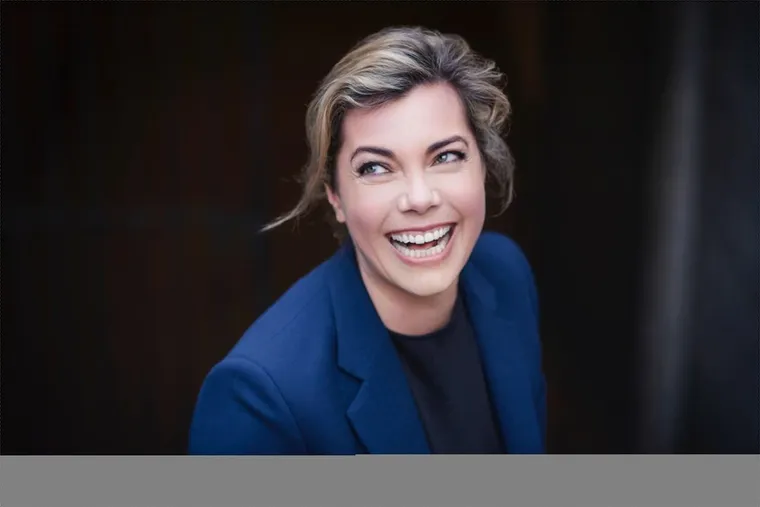 Anastassia Lauterbach smiling, wearing a blue blazer